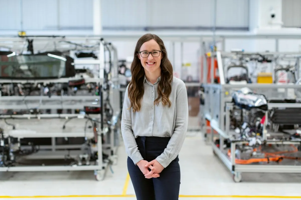 Woman factory owner on manufacturing floor reviewing industrial equipment