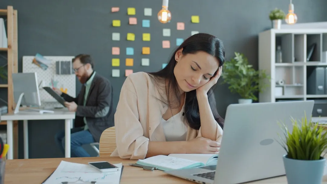 Woman business owner reviewing loan denial letter at laptop in office
