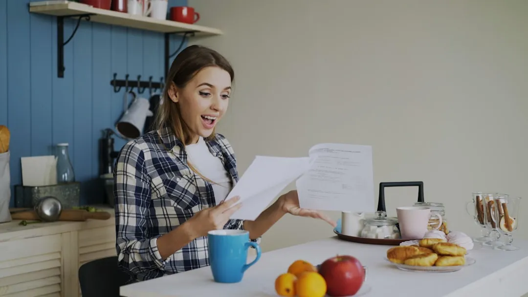 Woman with concerned expression reading tax documents at table