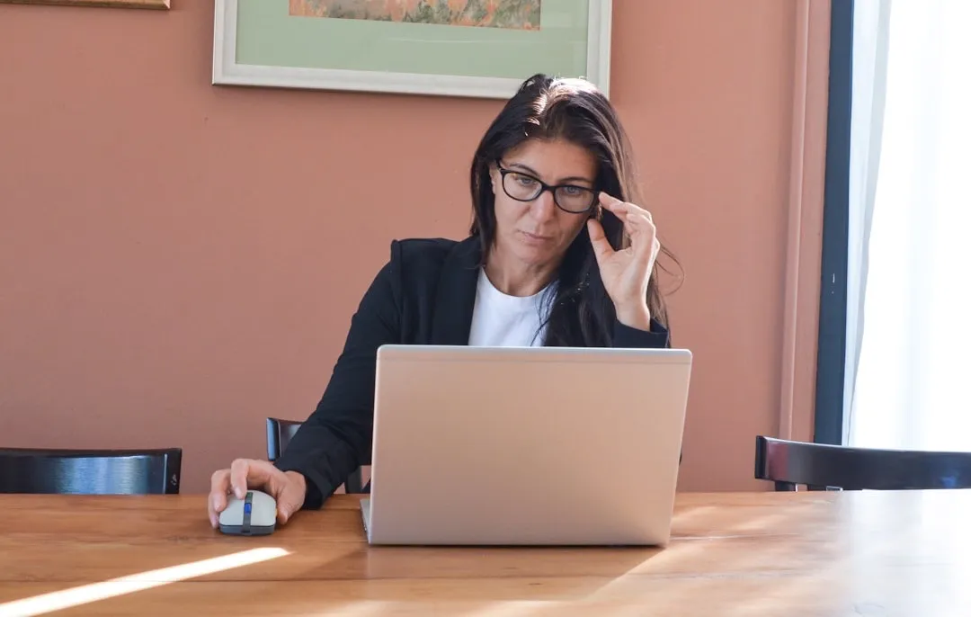 Woman reviewing credit report at computer screen with financial documents