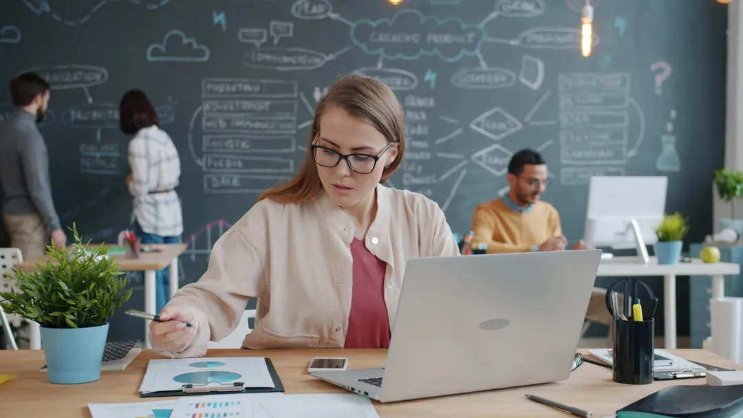Woman entrepreneur reviewing financial data and charts in a modern office
