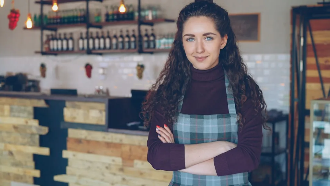 Immigrant woman small business owner standing in her restaurant with a concerned expression