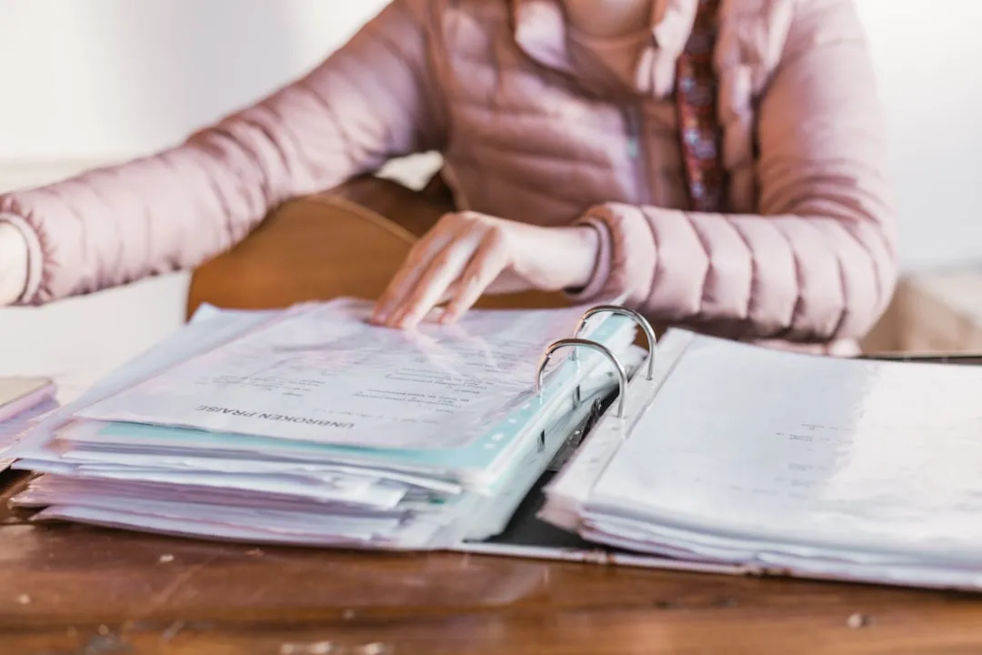 Self-employed woman organizing financial records and invoices at desk