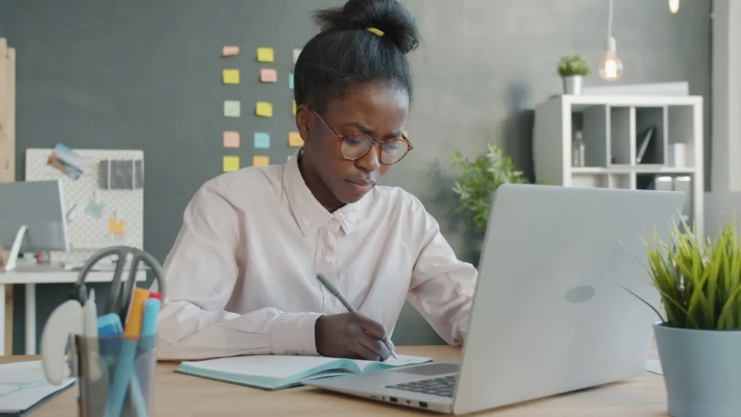 Woman working at desk reviewing financial documents