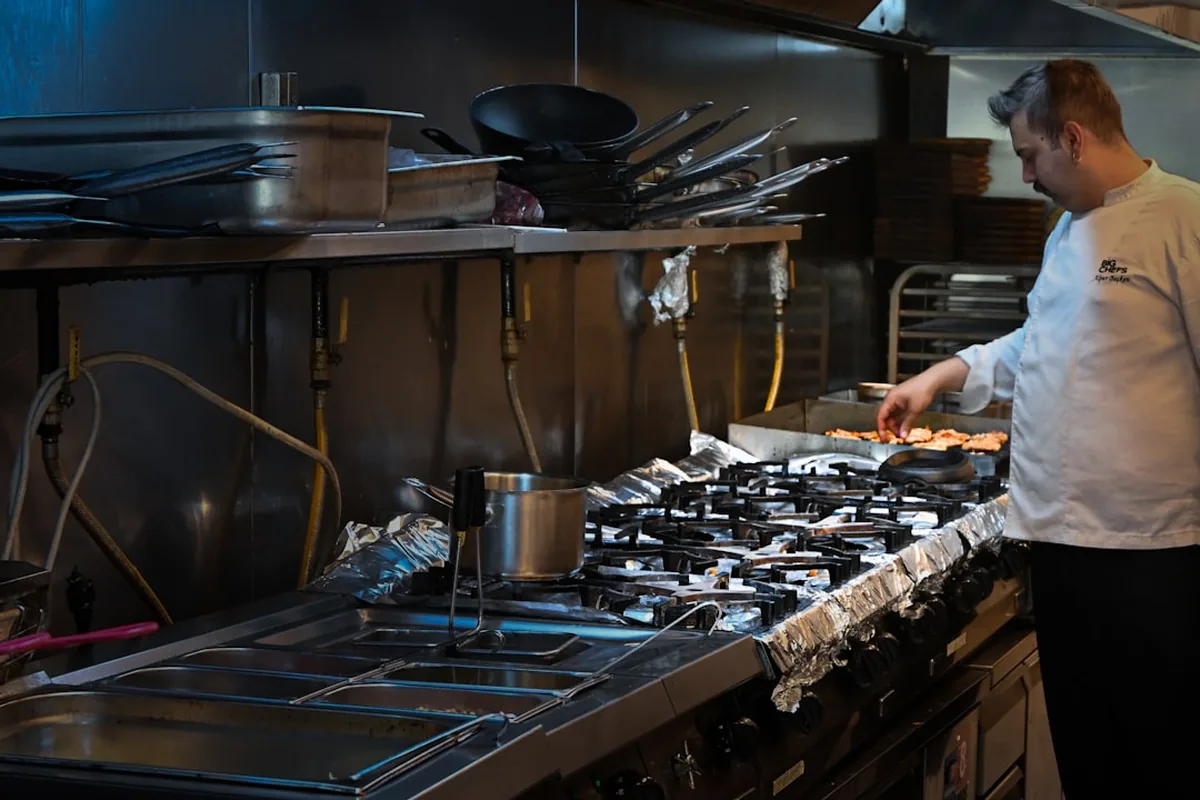 A professional catering team plating food in a commercial kitchen